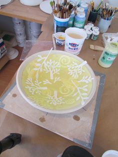 a white plate sitting on top of a table covered in paint