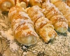 several pastries sitting on top of a plate covered in powdered sugar