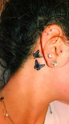 a woman with butterfly tattoos on her ear