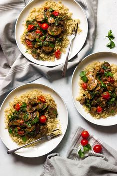 three plates with rice, mushrooms and cherry tomatoes on them next to a fork and napkin