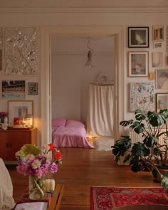 a living room filled with furniture and lots of pictures on the wall next to a bed