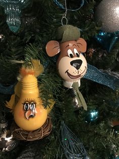 two ornaments are hanging on the christmas tree