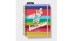 a spiral notebook with the words, my life is my business written on it and rainbow stripes