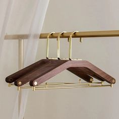 a pair of wooden clothes hangers hanging from a rail