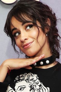 a close up of a person wearing a black shirt with a necklace on it's neck