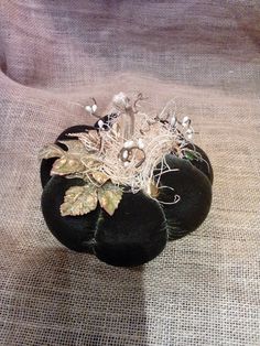 a black hat with leaves and pearls on it