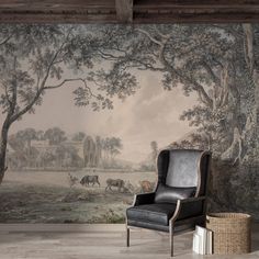 a chair sitting in front of a wall with a painting on it