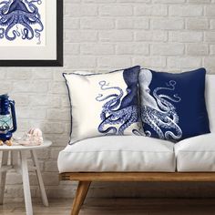 two blue and white pillows sitting on top of a wooden bench next to a table