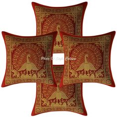 three red and gold pillows with peacocks on them