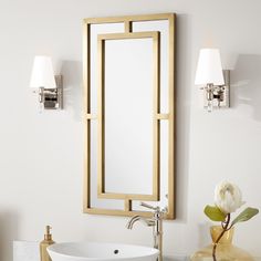 a bathroom sink sitting under a mirror next to a wall mounted faucet with lights on it