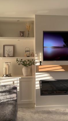 a flat screen tv mounted to the side of a wall next to a fire place