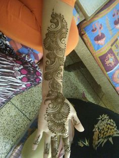 a woman's hand with henna tattoos on it and the bottom half of her arm