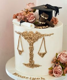 a graduation cake decorated with flowers and a judge's hat