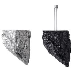 two pieces of rock are shown in black and white, one is shaped like an arrow