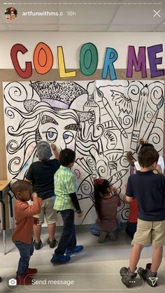 children are standing in front of a wall with the word color me painted on it