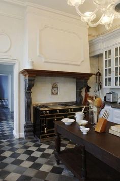 an old fashioned kitchen with black and white checkered flooring on the tile floors