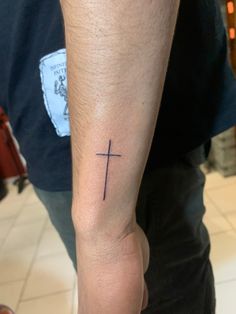 a man with a cross tattoo on his arm