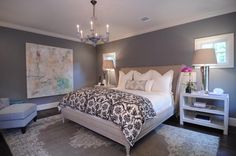 a bedroom with a large bed, chandelier and two nightstands in it