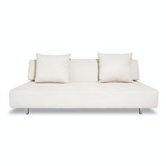 a white couch with three pillows on it's back and one arm folded up