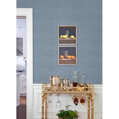 a gold table with drinks on it in front of a blue wall and white walls