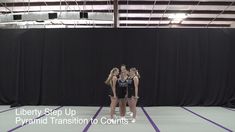 three young women standing on top of a purple and white floor in front of a black curtain