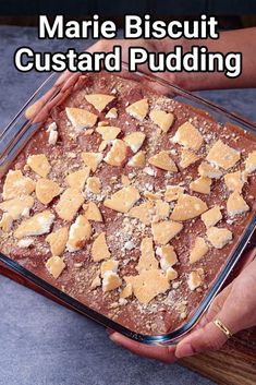 a person holding a pan filled with food on top of a wooden cutting board and text reading marie biscuit custard pudding