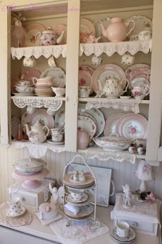 an old china cabinet is filled with dishes and other antique items, such as teapots