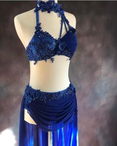 a woman's blue belly dance costume on display in front of a mannequin