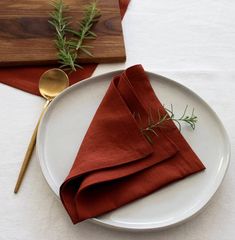 a white plate topped with red napkins next to a wooden cutting board