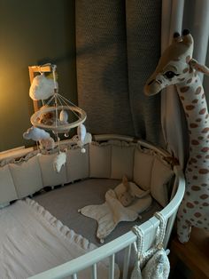 a baby crib with a giraffe stuffed animal next to it