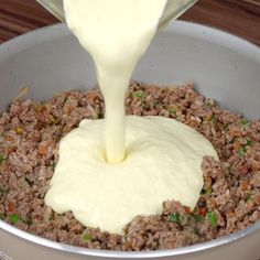 a pot filled with meat and sauce being poured into the pot to make an appetizer