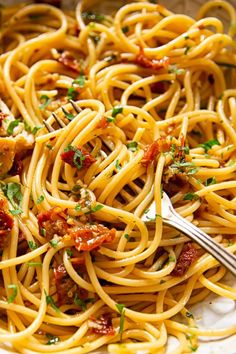 a plate full of spaghetti with sauce and parsley