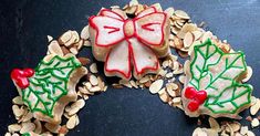 cookies decorated with holly leaves and bows on top of oatmeal flakes