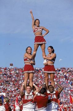 the cheerleaders are doing stunts in front of an audience at a football game