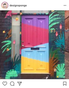 a colorful door painted on the side of a brick building with palm trees and flowers