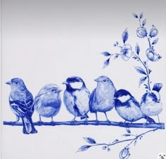 a group of birds sitting on top of a blue and white plate with flowers in the background