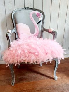 an old chair with a pink feathered seat cover and a flamingo print on the back