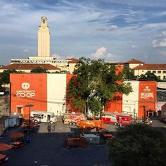 an orange building with a clock tower in the background and other buildings around it, as seen from above