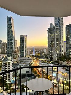 a balcony with a table and chairs overlooking the city