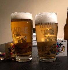 two beer glasses sitting next to each other on a table