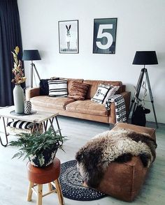 a living room filled with lots of furniture next to a wall covered in pictures and plants