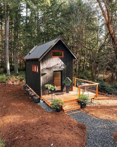 a small cabin in the middle of a wooded area with steps leading up to it