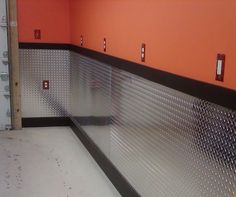 an empty room with orange walls and metal grates