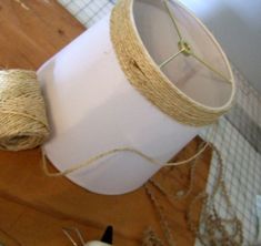 some twine and scissors are sitting on a table next to a white container with yarn