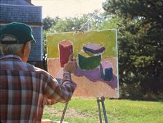 an older man is painting in the yard