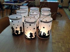 several lit candles sitting on top of a wooden table