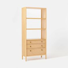 a wooden bookcase with drawers in front of a white background and an empty wall behind it