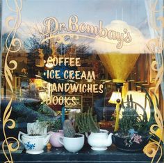 a window display with coffee cream sandwiches and potted plants