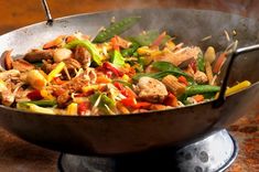 a wok filled with stir fry vegetables and meat