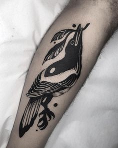 a black and white bird tattoo on the arm